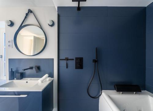 a blue bathroom with a sink and a mirror at Le Pavillon des Capitans in Juliénas