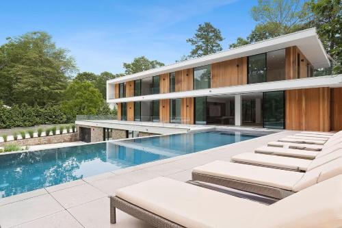 ein Haus mit einem Swimmingpool davor in der Unterkunft Brightwater by Rove Villa with Sauna Pool and Outdoor Spaces in East Hampton