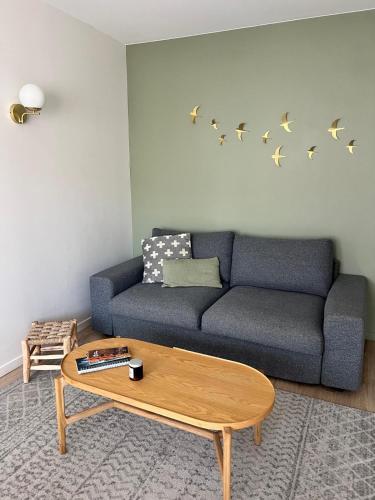 un salon avec un canapé bleu et une table basse dans l'établissement Charmant T2, hyper-centre, à 50m de la plage !, à Le Touquet-Paris-Plage