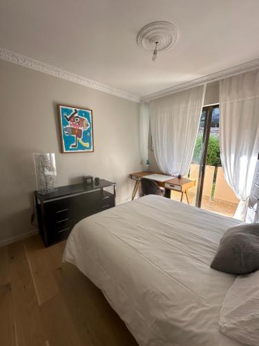 une chambre avec un lit, un bureau et une fenêtre dans l'établissement Appartement de standing, vue mer, 3 chambres, à Ajaccio