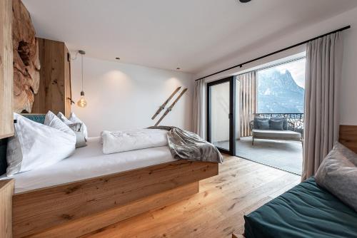 a bedroom with a bed with a view of a balcony at Krahof Dolomites - Urlaub auf dem Bauernhof in Castelrotto