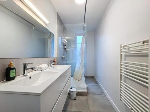 a white bathroom with a sink and a mirror at Appartement neuf, 4 Chambres ,Spacieux TV-WIFI in Clermont-Ferrand