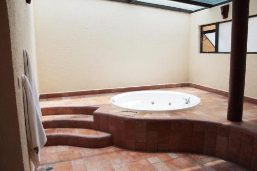 a bathroom with a bath tub in a room with stairs at Hotel Real Ocotepec in Cuernavaca