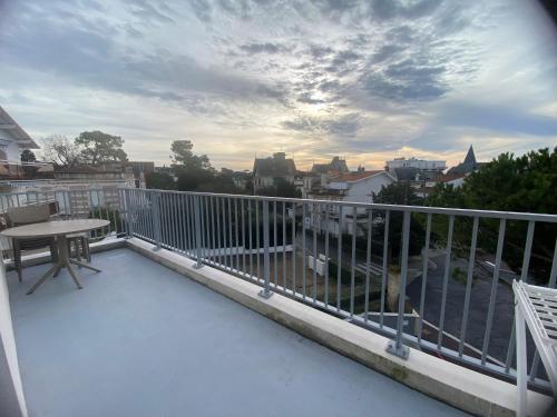 Un balcón con una mesa y vista a una ciudad. en L'orée Royannaise, en Royan