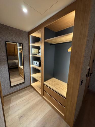 a walk in closet with wooden shelves and a mirror at Hotel Petit Lacreu in Salardú