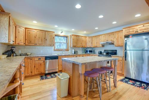 a kitchen with wooden cabinets and a large island with bar stools at Benton Home on 50 Acres with Private Deck and Views! in Benton