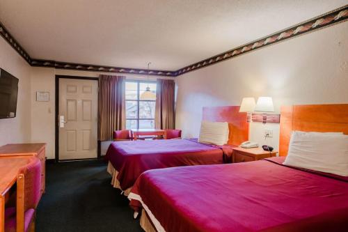 a hotel room with two beds with red sheets at Gatlinburg Motel in Gatlinburg