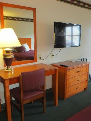 a bedroom with a desk and a bed and a television at Gatlinburg Motel in Gatlinburg