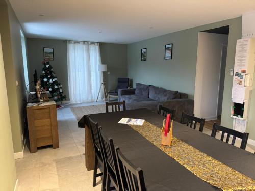 a living room with a table and a christmas tree at Gite 10 pers in Murol