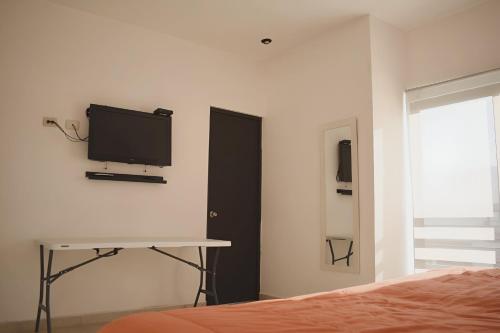 a bedroom with a bed and a tv on the wall at ALBERCA 3 HABITACIONES, CERCA DE LA PLAYA, Cantera Residencial in San Carlos