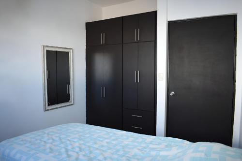 a bedroom with a bed and a black cabinet at ALBERCA 3 HABITACIONES, CERCA DE LA PLAYA, Cantera Residencial in San Carlos