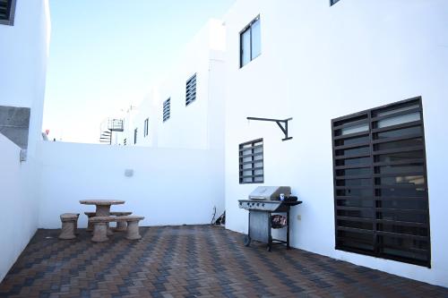 a room with a table and a bench and a stove at ALBERCA 3 HABITACIONES, CERCA DE LA PLAYA, Cantera Residencial in San Carlos