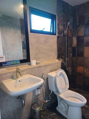 a bathroom with a toilet and a sink and a window at PaKrongCheep Homestay in Ban Muang Mai