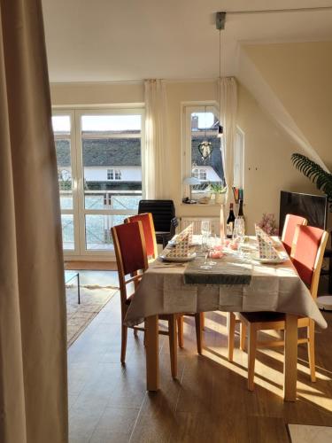 a dining room with a table and chairs at Schaake Hooksiel - Charmante Reetdachwohnung & Kostenfreier Parkplatz in Hooksiel