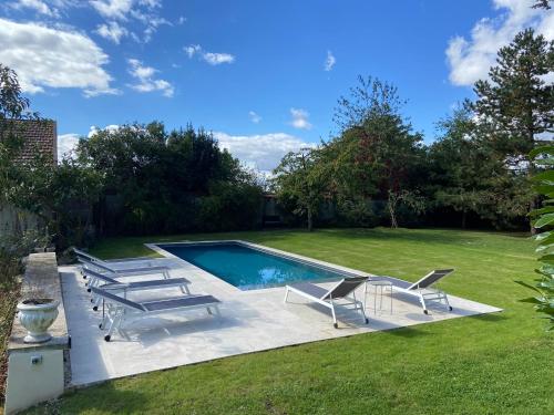 - une piscine avec des chaises longues et une pelouse dans l'établissement Bel Air, à Bois-le-Roi