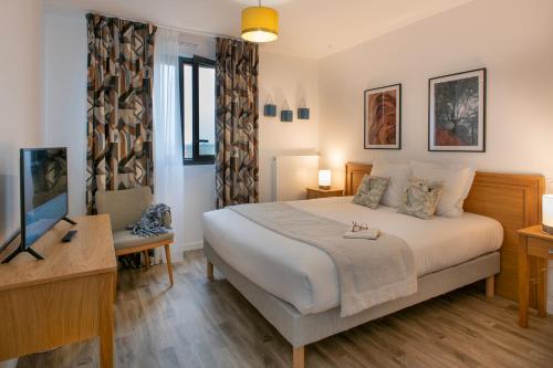 a bedroom with a large bed and a television at DOMITYS L'ALLIACEE - Résidence Services Séniors in Achères