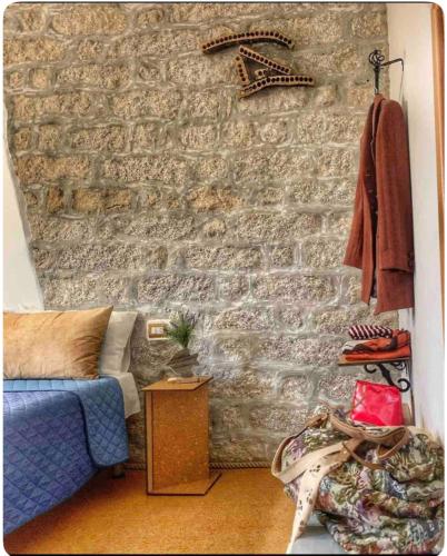 a room with a stone wall with a blue couch at La Vecchia Posta B&B in Calangianus