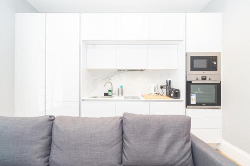 a living room with a couch and a microwave at Luxury Apartments In Paddington in London