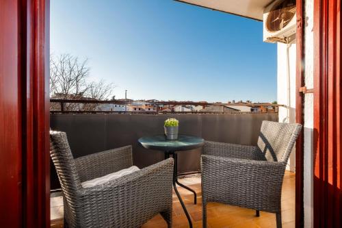 a balcony with two chairs and a table and a view at Apartments Luce in Rovinj