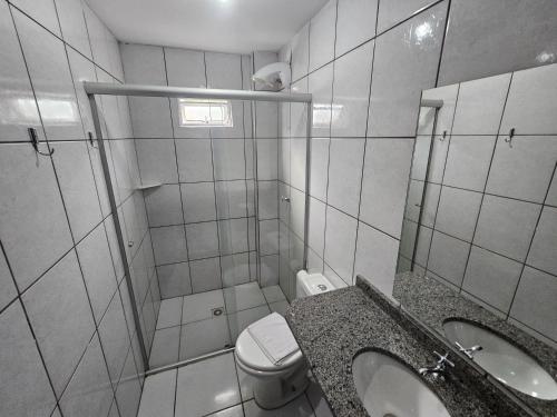 a bathroom with a toilet and a sink and a shower at Ok Inn Hotel Criciúma Centro in Criciúma