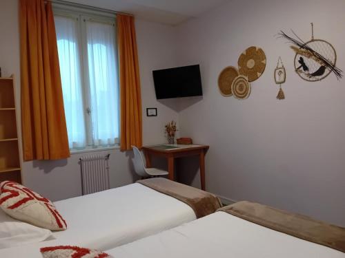 a hotel room with two beds and a desk at Hôtel de la Plage in Fécamp