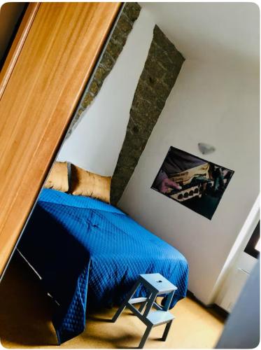 a bedroom with a blue bed in a attic at La Vecchia Posta B&B in Calangianus