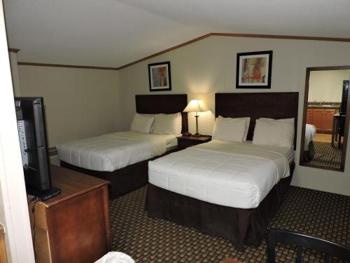 a hotel room with two beds and a television at El Dorado Suites in Crystal City