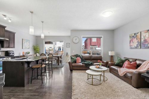 a living room and kitchen with a couch and a table at Large Family 4BR w Kid's Play Den! FREE Banff Pass in Calgary