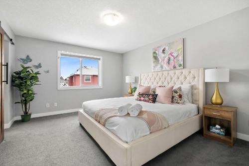 ein Schlafzimmer mit großem Bett und Fenster in der Unterkunft Large Family 4BR w Kid's Play Den! Near Airport & Shopping! FREE Banff Pass, BBQ, Netflix, Parking & Wine! in Calgary