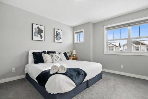 a bedroom with a large bed with two towels on it at Large Family 4BR w Kid's Play Den! FREE Banff Pass in Calgary