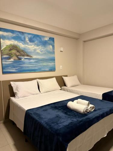 two beds sitting next to each other in a room at Pousada La Acolhida in Cabo Frio
