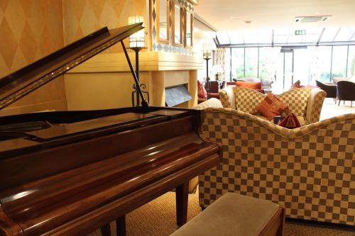 a living room filled with furniture and a piano at Brook Mollington Banastre Hotel & Spa in Chester
