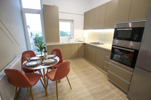 a kitchen with a table and chairs and a kitchen with a stove at Mianelly Center in Constanţa