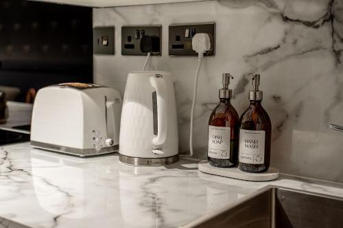 a counter with two bottles of wine and a toaster at Sutherland mini apartments in Fort William