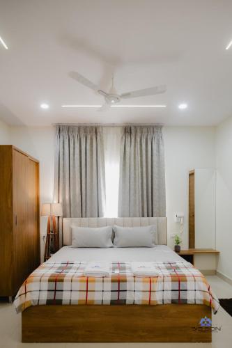 a bedroom with a bed and a ceiling fan at Bigson Blissful Studios in Hyderabad