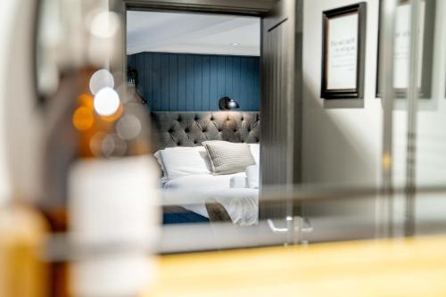 a reflection of a bedroom with a bed in a mirror at Sutherland mini apartments in Fort William