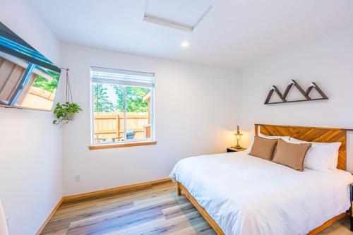a white bedroom with a bed and a window at Grouse in Law Hikers Paradise in Port Angeles