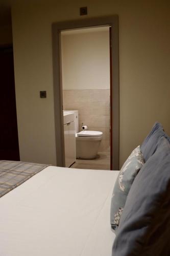 a bedroom with a bed and a bathroom with a toilet at The Pig Inn in Snaith