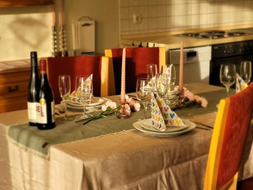 a table with wine bottles and glasses on it at Schaake Hooksiel - Charmante Reetdachwohnung & Kostenfreier Parkplatz in Hooksiel