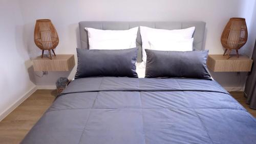a bedroom with a bed with blue sheets and two lamps at Apartament Stary Tartak in Ostróda