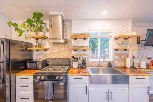a kitchen with white cabinets and a stainless steel appliances at Rivers Edge river side tiny home in Port Angeles