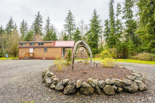 a garden in front of a house with a building at ElkCreek Inn Creekside tiny home in Forks