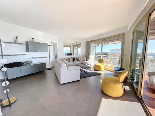 - un salon avec un canapé blanc et un fauteuil jaune dans l'établissement Croisette - 2 Bedrooms - Panoramic sea view, à Cannes