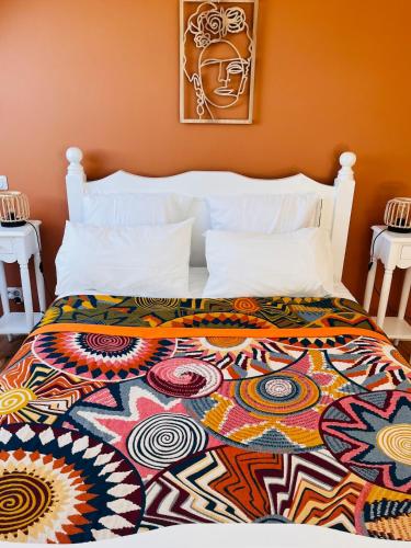 - une chambre avec un lit et une couverture colorée dans l'établissement Petit loft de charme en centre Bretagne - Brocéliande, à La Croix-Helléan