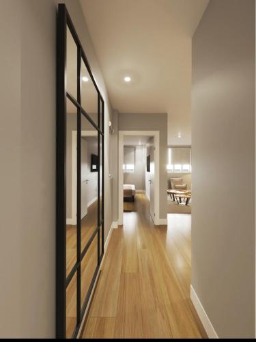 a hallway with a mirror and a living room at Apartamentos Ovetum in Oviedo