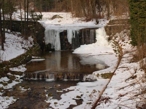 a waterfall in the snow with snow on the ground at Guest House U Lakomce in Desná
