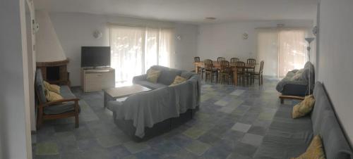 un salon avec un canapé, des chaises et une télévision dans l'établissement Casa Rural La Dehesa de Campoviejo, à Robledillo de Trujillo