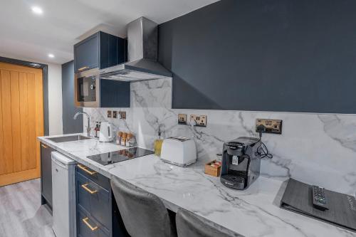 a kitchen with a marble counter top with a coffee maker at Sutherland mini apartments in Fort William