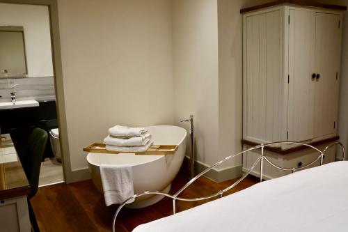 a white bathroom with a sink and a bed at The Pig Inn in Snaith