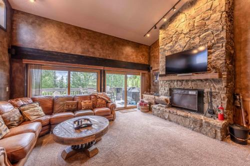 un soggiorno con divano e camino di Outdoor Pool, Private Sauna, 50yd to Moose Creek Lift, Flexible Bedding a Teton Village